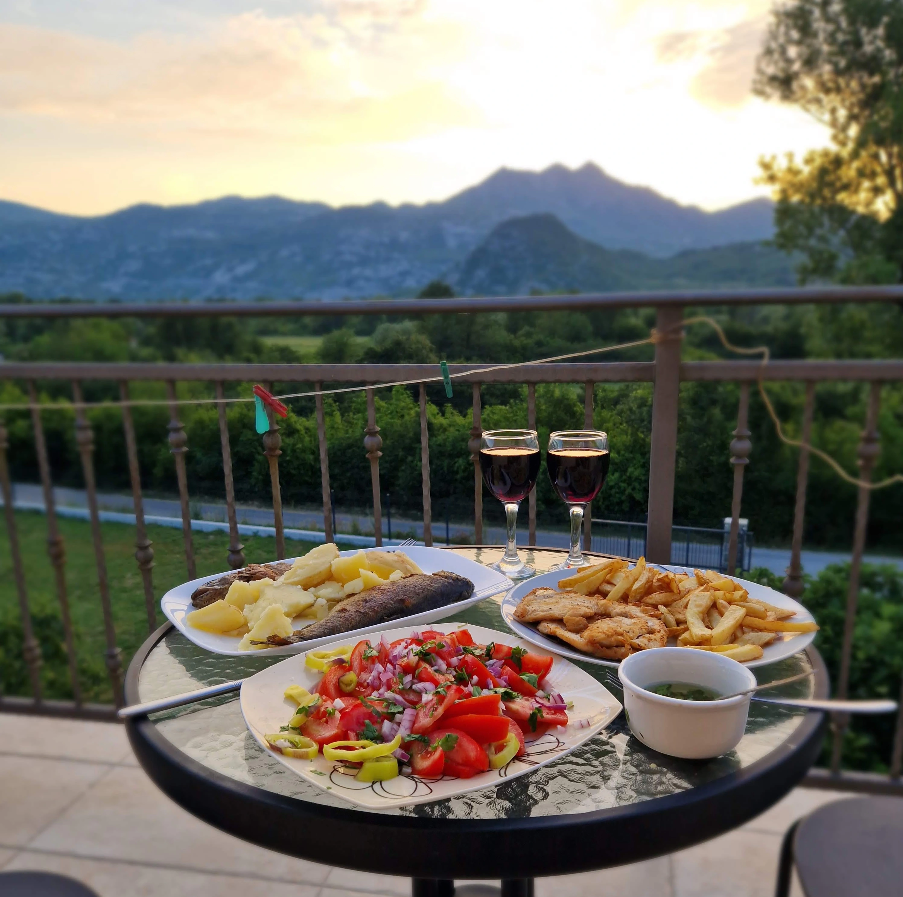 Traditional trout dinner and homemade wine at sunset over Lake Skadar