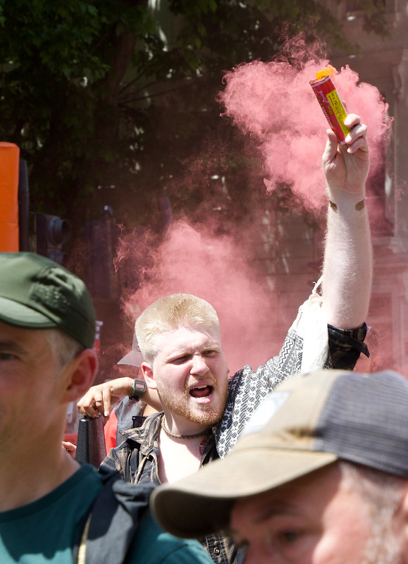 A man holding a flare in a Pro-Palestine protest in London